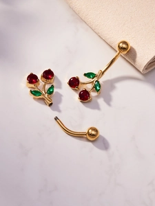 Detailed macro view of cherry navel ring showing gold screw thread and red gemstones