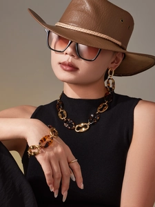 Macro view of vintage gold metal and tortoiseshell resin jewelry set on a model