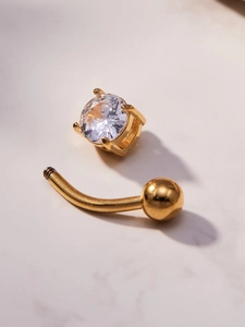 Macro detail of 18k gold-plated belly piercing featuring sparkling 5A cubic zirconia stones