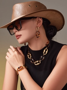 Detail of vintage gold-tone chain jewelry set with tortoiseshell resin and pearl ring