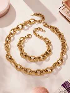 Dettaglio del set collana e bracciale a catena spessa in acciaio placcato oro 18 carati