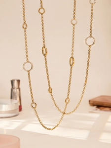 Nahaufnahme einer goldenen Pulloverkette mit polierten Ringen und Zirkon-Detail