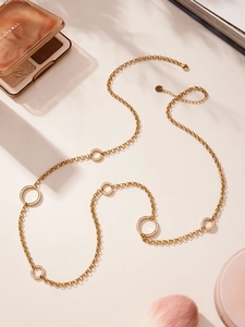 Detail einer langen goldenen Pulloverkette mit doppellagigen Zirkonia-besetzten Anhängern