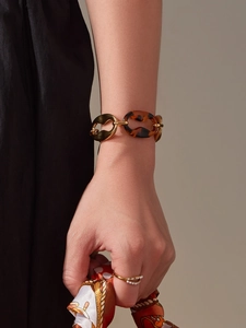 Detail of vintage gold chain bracelet with tortoiseshell resin links worn on a wrist