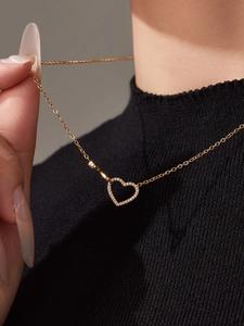 Primo piano della collana con ciondolo a cuore dorato e cristalli pavé scintillanti