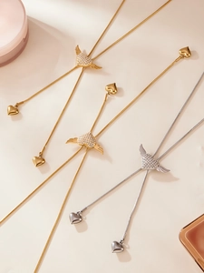 Close-up of winged heart pendants with 5A zircons in gold and silver finishes