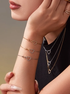 Dettaglio di elegante set di gioielli a forma di cuore con micro-cristalli su modella