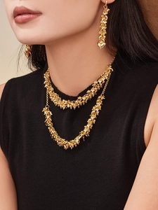 Detailed view of layered 18k gold plated stainless steel heart tassel necklace and earrings