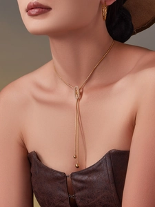 Détail du collier plaqué or 18 carats avec anneau en zircon et longues chaînes pendantes
