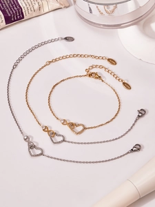 Dettaglio di collana e bracciale in acciaio inossidabile con cuore infinito e zirconi