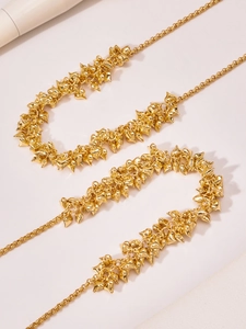Macro shot of gold stainless steel necklace with multiple heart pendants and polished finish