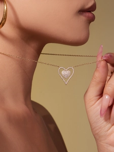 Detail of 18k gold plated double heart pendant necklace with shimmering zircon stones