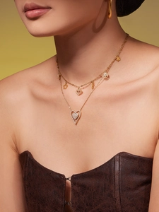 Close-up of double-layered gold heart and tree of life pendant necklace set