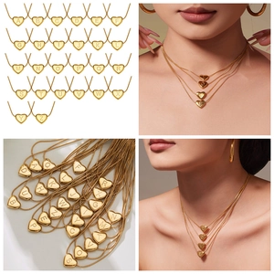 Close-up of 18k gold plated heart initial pendants on delicate snake chains for women