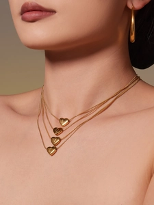 Detail shot of multi-layer 18k gold plated heart pendants engraved with LOVE on a model