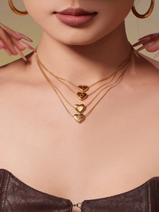 Detail of four-layered gold heart necklaces with LOVE letter pendants on snake chains