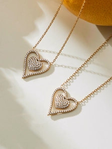 Detail of double-layer heart pendant necklace with gold plating and sparkling zircon stones