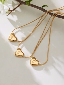 Detail view of 18k gold plated heart pendants with letters A, B, C on snake chains