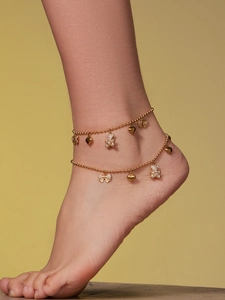 Detailed view of gold beaded anklets featuring zircon bear, heart and bow charms