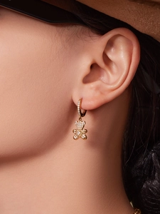 Macro view of gold teddy bear hoop earrings with sparkling cubic zirconia pavé stones