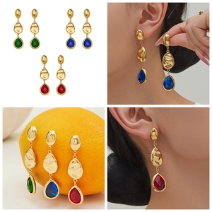 Detailed view of 18k gold plated drop earrings with faceted gemstones in red blue and green