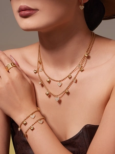 Detail view of model wearing a double-layer heart jewelry set in 18k gold finish