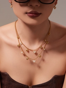 Detail shot of heart jewelry set featuring double-layered gold bead necklace and earrings