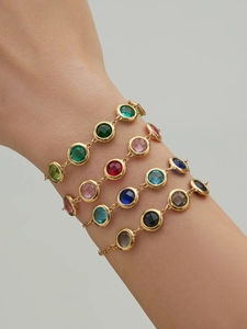 Detailed layering of 18k gold plated bracelets with vibrant multi-color faceted gemstones