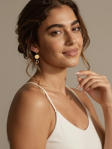 Détail d'une créole plaquée or 18k avec pendentif lettre D et disque rond gravé