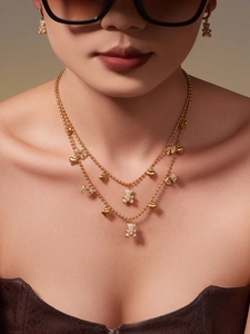 Detailed close-up of golden bear and heart charms on a layered bead chain necklace