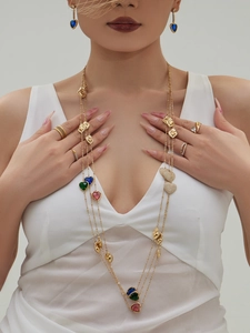 Primer plano del collar dorado multicapa con corazones de colores en modelo