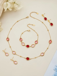 Detalle del conjunto de joyas en acero dorado con piedras rosas ovaladas talladas