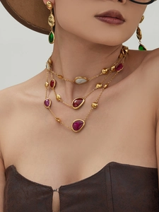 Detail view of gold layered necklace set with colorful resin stones and zircon on a model