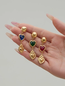 Vista detallada de aretes de corazón vintage con piedras azules verdes y rojas en oro