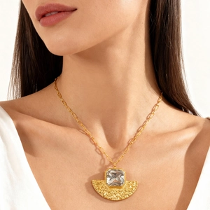 Détail du collier en or avec pierre transparente rectangulaire et pendentif en forme d'éventail