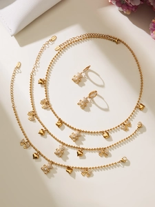 Macro detail of gold stainless steel heart and zircon bow charms with S.Steel engraving