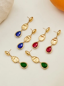 Detailed view of 18k gold faceted teardrop earrings with colorful gemstones