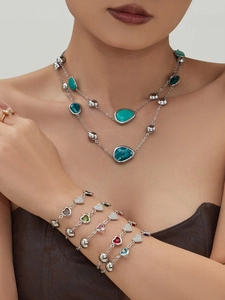 Detail of 18k gold plated necklace and heart bracelets set with 5A zircons and colorful resin