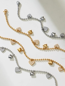 Detailed view of heart charms and ball chains in gold and silver stainless steel