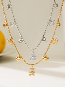 Detailed view of gold and silver beaded necklaces with CZ bear, bow, and heart pendants