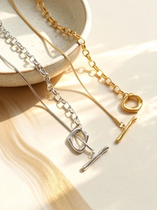 Dettaglio della chiusura a ginocchiera OT e catena a serpente su collana in acciaio oro 18k
