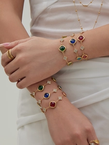 Detail view of gold floral bracelets with colorful gemstones and pavé zirconia accents