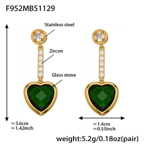 Detalle de pendientes de corazón en acero dorado con piedra verde y circonitas finas