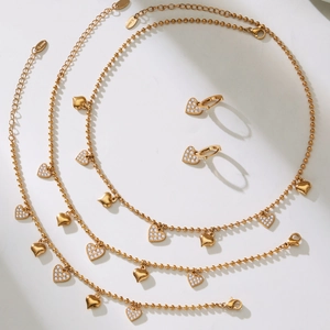 Golden heart jewelry set with beaded chains and zircon heart pendants in 18k gold finish