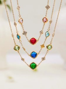 Detailed view of gold stainless steel necklaces with colorful gemstone pendants