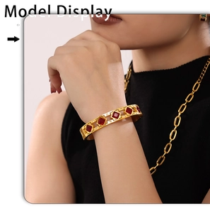 Detalle de brazalete dorado de lujo con gemas rojas y cristales en la muñeca de la modelo