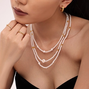 Collier de perles à trois rangs avec pendentifs marguerites pour un look floral élégant