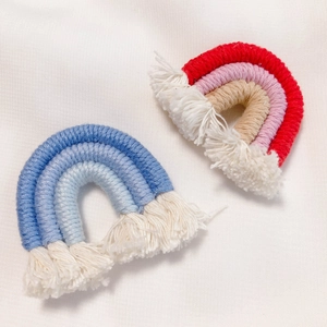 Detail of handmade woven rainbow charms with cotton tassels for DIY craft jewelry making