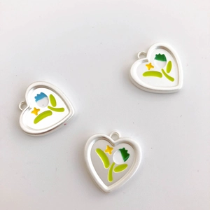 Macro detail of tulip heart enamel pendants with floral and star patterns in three colors