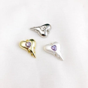 Detailed view of heart-shaped melt pendants with zircon in gold and silver finishes